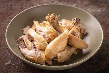 cut of boiled chicken in simply ceramic plate on rusty texture background