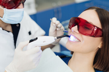 Close-up portrait of a female patient visiting dentist for teeth whitening in clinic