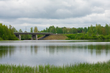 Fototapeta na wymiar Railway bridge above the Tuuralammi stream pool in Jämsänkoski, Finland on a gloomy summer day.