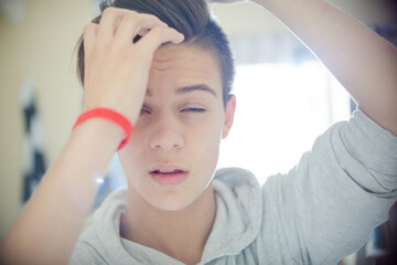 Portrait of teenage boy with hand in hair