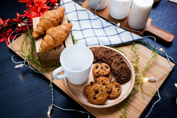 cookie and croissant on wooden tray