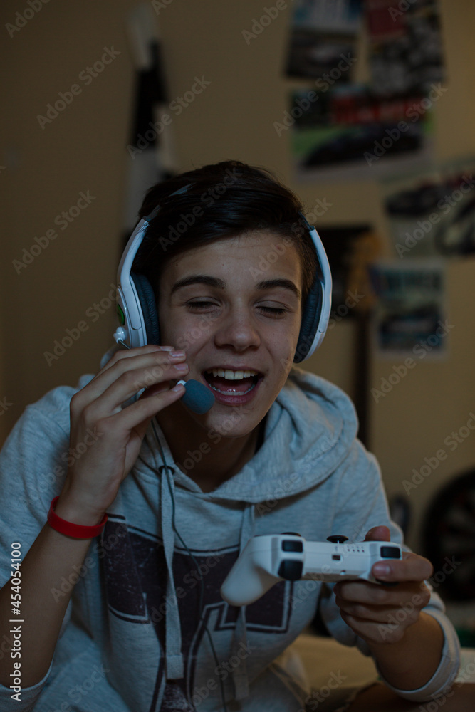 Wall mural Teenage boy with headset playing video game