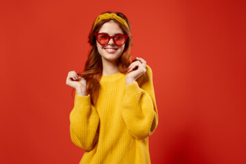 woman in yellow sweater wearing red glasses headband fashion red background