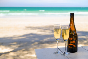 Two glasses of champagne on sand beach