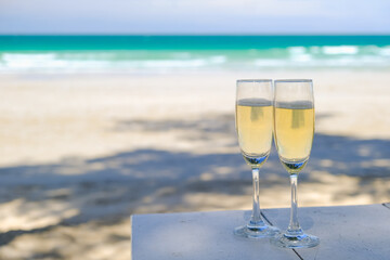 Two glasses of champagne on sand beach