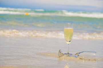 Two glasses of champagne on sand beach