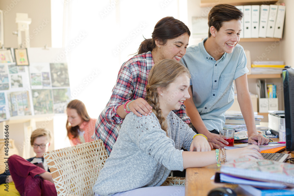 Wall mural group of teenagers using together computer in room