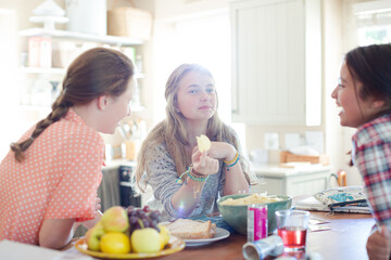 Obraz na płótnie Canvas Teenage girls learning at table in kitchen