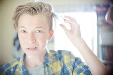 Portrait of teenage boy with hand in hair