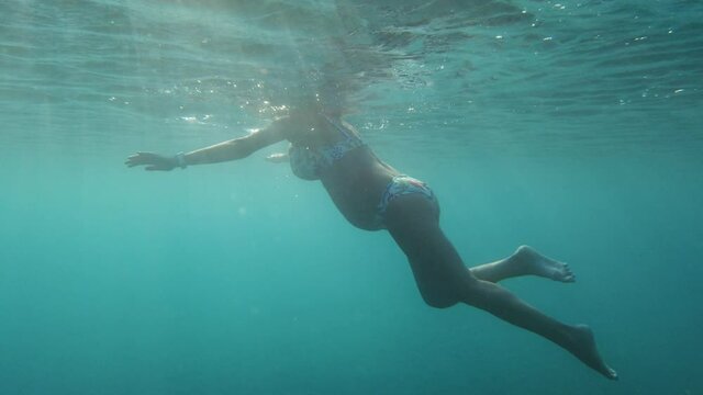 Donna incinta nuota nel mare durante la gravidanza