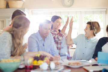 Group of teenagers doing high five in living room
