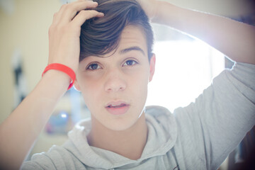 Fototapeta premium Portrait of teenage boy with hand in hair
