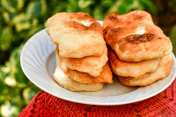 Traditional Bulgarian home made deep fried  patties  covered with sugar  оn rustic backgroud.Mekitsa or Mekica,  on wooden  rustic  background. Made of kneaded dough that is deep fried 