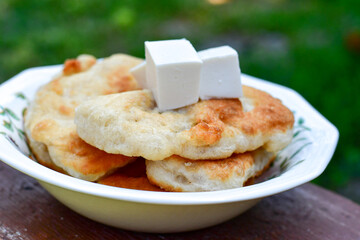 Traditional Bulgarian home made deep fried  patties  covered with sugar  оn rustic backgroud.Mekitsa or Mekica,  on wooden  rustic  background. Made of kneaded dough that is deep fried 