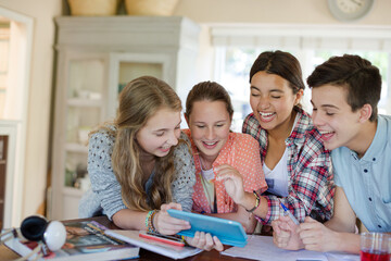 Group of smiling teenagers taking selfie in dining room