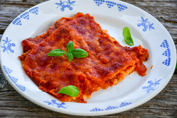   Delicious Home made keto diet  Lasagna bolognese  with  Lupin Flour, minced meat,tomato sauce and spinach  on a wooden rustic  background.Home made low carb italian meal
