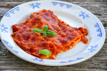   Delicious Home made keto diet  Lasagna bolognese  with  Lupin Flour, minced meat,tomato sauce and spinach  on a wooden rustic  background.Home made low carb italian meal