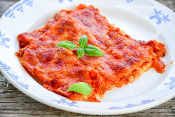   Delicious Home made keto diet  Lasagna bolognese  with  Lupin Flour, minced meat,tomato sauce and spinach  on a wooden rustic  background.Home made low carb italian meal