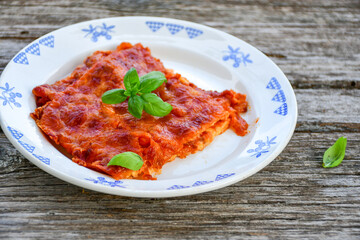   Delicious Home made keto diet  Lasagna bolognese  with  Lupin Flour, minced meat,tomato sauce and spinach  on a wooden rustic  background.Home made low carb italian meal