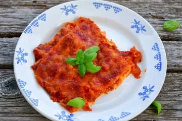   Delicious Home made keto diet  Lasagna bolognese  with  Lupin Flour, minced meat,tomato sauce and spinach  on a wooden rustic  background.Home made low carb italian meal