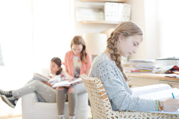 Three teenage girls doing homework in room