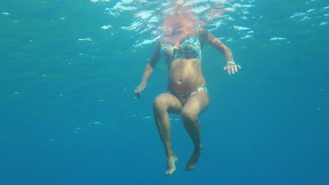 Donna incinta nuota nel mare durante la gravidanza