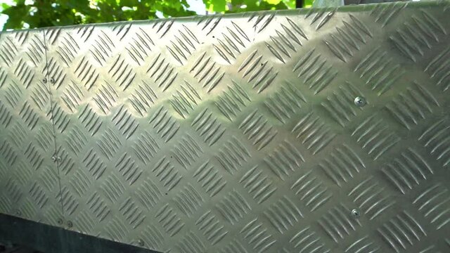 Corrugated aluminum sheets. Sheathing of a car trailer. Metal protection. Design element. Outside. Self made. Cargo board. Close-up.