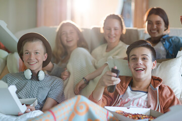 Obraz na płótnie Canvas Group of teenagers watching tv on sofa together
