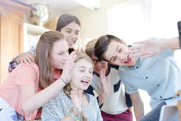 Obraz premium Group of teenagers waving while communicating via internet