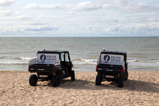zwei fahrzeuge der polizei ostende stehen am strand, august 2021