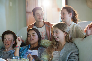 Fototapeta na wymiar Group of teenagers having fun while watching tv on sofa