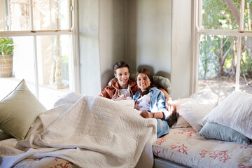 Fototapeta premium Teenage couple lying in bed and watching tv