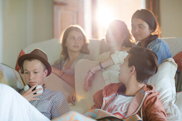 Group of teenagers having fun while watching tv on sofa