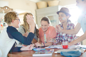 Group of teenagers doing high five in living room