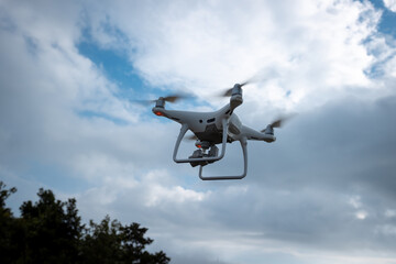 White drone with camera flying in summer mountain top