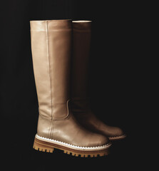 Black women high wellington boots on a black background. Female autumn and winter footwear concept