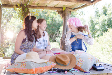Three teenage girls wearing wigs hat while sitting in tree house in summer