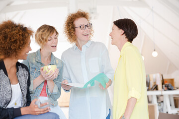 Fototapeta premium Women with coffe cup talking in office