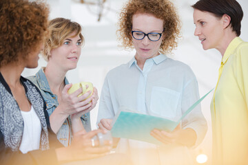 Women with coffe cup talking in office