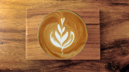 Fototapeta na wymiar a cup of latte art coffee on wooden background 