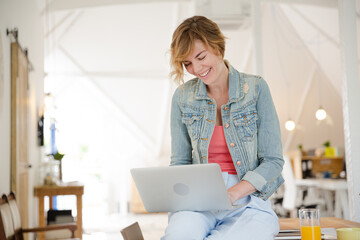 Obraz premium Portrait of woman sitting at desk with laptop in office