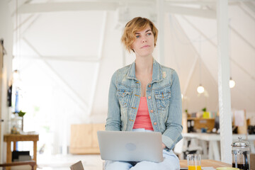 Portrait of woman sitting at desk with laptop in office