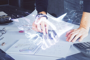 Double exposure of man's hands holding and using a digital device and handshake drawing....