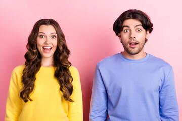 Photo of young excited couple happy positive smile amazed surprised wow information sale isolated over pink color background