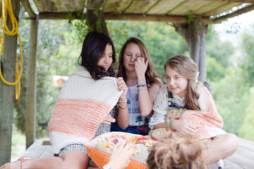 Three teenage girls playing in tree house in summer