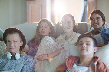 Group of teenagers watching tv on sofa together