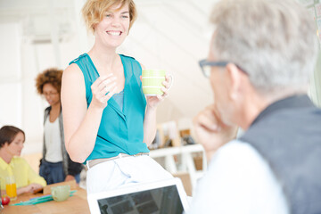 Man and woman sitting in office,smiling and talking