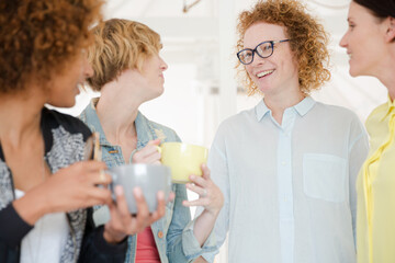 Women with coffe cup smiling in office