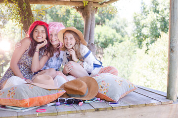 Three teenage girls wearing wigs hat while sitting in tree house in summer