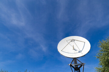 Big white satellite dish on a blue sky